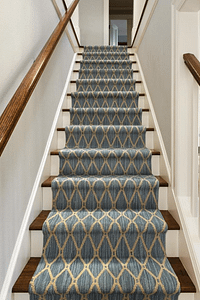 Dark grey patterned stair runner on wooden staircase.
