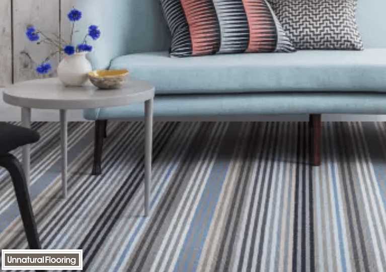 Multi coloured Unnatural Flooring Stripe Surf Botany carpet in a contemporary style living room featuring a low level sofa and matching coffee table.