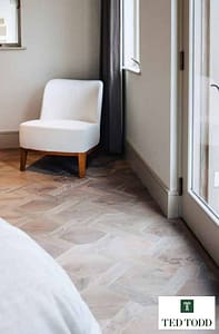 Light Coloured Ted Todd Avery European Oak parquet flooring, in a modern bedroom setting with white furnishings and glass French doors.