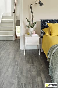 Amtico Spacia dark grey wood planking effect flooring in a bedroom setting.