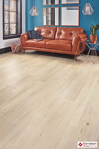 Light coloured Karndean Knight Tile Natural Scandi Pine flooring in a contemporary style living room featuring a large tan leather sofa.