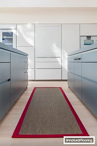 Unnatural Flooring UF1006 charcoal rug with red binding in a modern style kitchen with grey fronted units.