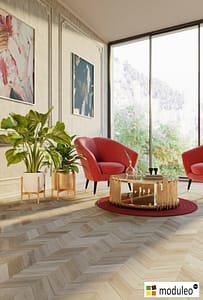 Moduleo Bohemian Oak 61254 flooring in a contemporary style living space with two red bucket chairs in front of floor to ceiling windows.
