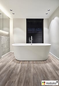Moduleo Mexican Ash 20965 flooring in a modern style bathroom with a large white free standing bathtub.