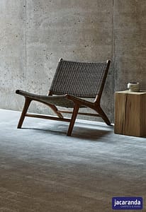 Light grey Jacaranda Arani Platinum carpet in a modern style room, under low backed wooden slatted chair.