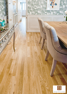 Tan coloured V4 Three Strip Oak flooring in a contemporary dining room with a large wooden table and chairs.