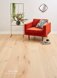 Light coloured Ted Todd Project Petworth flooring in a contemporary style room with a burnt orange box style chair and thin metal framed furniture.