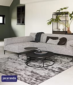Mixed grey Jacaranda Santushti Fossil rug in a contemporary style living room with a low backed corner sofa unit in light grey.