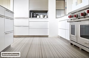 Mixed colour Oyster Unnatural Flooring in a modern style kitchen with white fronted units and a stainless steel oven.