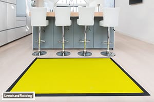 Lime coloured Unnatural Flooring UF1020 rug in a modern style kitchen featuring four metal framed stools with high backed cream seats.