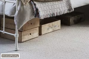 Unnatural Flooring Crafty Diamond Briolette wool carpet under a traditional style metal framed bed with wooden storage crates underneath.