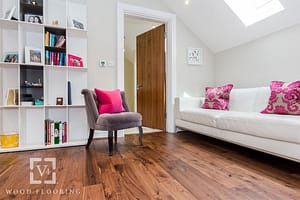 Dark tan coloured V4 Alpine laminate flooring in an attic room under a modern looking white low backed sofa.