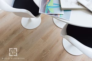 Tan coloured V4 Deco laminate flooring under a modern looking white table and matching bucket chairs.