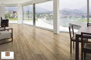 Mixed tan V4 Haybluff Oak Laminate flooring in a modern living space with floor to ceiling windows overlooking a river.