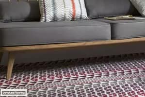 Unnatural Flooring Fair Isle Reiko carpet under a contemporary style grey wooden framed sofa.