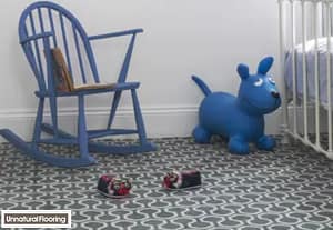 Unnatural Flooring Honeycombe Duck Egg carpet in a child's nursery featuring a blue plush animal, wooden rocking chair, and metal framed cot.