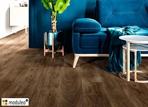 Moduleo Laurel Oak 51852 flooring in a modern style living space with a blue feature wall and matching furniture.