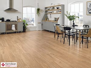 Tan coloured Karndean Looselay Champagne Oak flooring in a contemporary style kitchen dinner with grey fronted units and a wooden table and chair set.